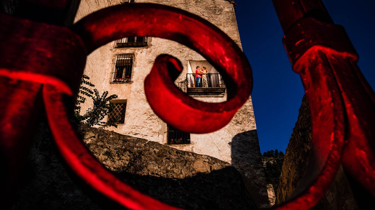 pareja asomado al balcón al fondo